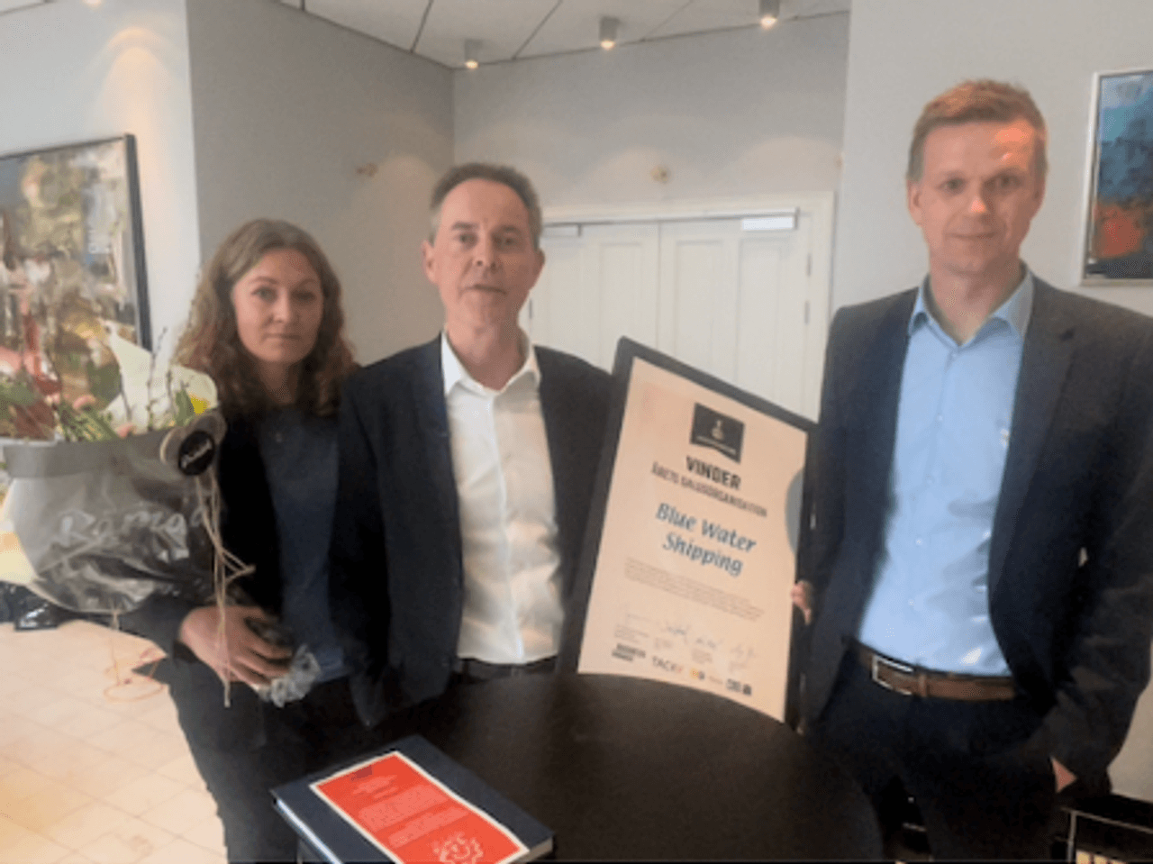 Martin Brandstrup med vinderdiplomet flankeret af kollegerne Lise Handberg og Jeppe Rind Stentoft fra Blue Water Shipping 